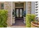 Elegant entryway with stone accents, double doors, decorative plants, and brick paver steps at 8434 Dunham Station Dr, Tampa, FL 33647