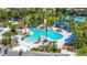 Aerial view highlights the freeform Gathering pool with slides, sun loungers, and lush landscaping with palm trees at 8434 Dunham Station Dr, Tampa, FL 33647