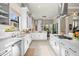 A modern white kitchen boasts sleek countertops, stainless steel appliances, and a view to the dining area at 8434 Dunham Station Dr, Tampa, FL 33647
