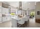 A bright, white kitchen is centered around a large island with pendant lighting and barstool seating at 8434 Dunham Station Dr, Tampa, FL 33647