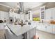 A white kitchen has modern appliances, plenty of cabinet space, and barstool seating at the center island at 8434 Dunham Station Dr, Tampa, FL 33647