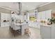 A bright, white kitchen features stainless appliances, a large center island, and tile flooring at 8434 Dunham Station Dr, Tampa, FL 33647