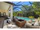 Screened-in pool and spa with fire pit and lounge area at 8434 Dunham Station Dr, Tampa, FL 33647