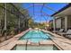 Long rectangular screened in pool with spa and lounge chairs at 8434 Dunham Station Dr, Tampa, FL 33647