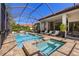 Relaxing outdoor pool area featuring a screened-in pool, spa, and covered patio with lounge seating at 8434 Dunham Station Dr, Tampa, FL 33647