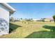 Scenic backyard view with vibrant green grass, complemented by serene surroundings and neighboring properties at 8529 Regal Ln, Hudson, FL 34667