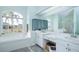 Well-lit bathroom featuring double sinks, a soaking tub, and a large window at 8529 Regal Ln, Hudson, FL 34667