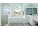 Bright bathroom featuring a large tub under a window, a glass shower, and modern fixtures at 8529 Regal Ln, Hudson, FL 34667