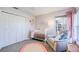 Charming Bedroom featuring a white crib, cozy armchair, and soft pink accents at 8529 Regal Ln, Hudson, FL 34667
