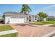 Bright single-story home with a brick driveway, a two-car garage and well-maintained landscaping at 8529 Regal Ln, Hudson, FL 34667