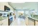Well-lit kitchen with granite countertops, modern appliances, and a view of the dining area at 8529 Regal Ln, Hudson, FL 34667