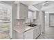 Functional kitchen with window over the sink, bright cabinets, and sleek, white appliances at 9529 Bunker Hill Ct, New Port Richey, FL 34655