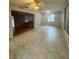 Open living room showcasing neutral tile flooring, a ceiling fan, and ample natural light from the window at 977 Gershwin Dr, Largo, FL 33771