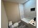 Bright bathroom featuring a new toilet, bathtub, tiled shower, and modern vanity with dark fixtures at 10116 N Highland Ave, Tampa, FL 33612