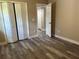 Bedroom features neutral walls, wood-look flooring, white trim, and a closet with bi-fold doors at 10116 N Highland Ave, Tampa, FL 33612