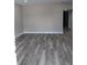Living room with gray flooring, base trim, and open floorplan at 10116 N Highland Ave, Tampa, FL 33612