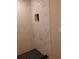 Bright white shower with black tiled floor and corner shelf, accented by natural light at 10116 N Highland Ave, Tampa, FL 33612
