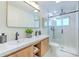 Stylish bathroom showcasing a double sink vanity with wood accents, a frameless glass shower, and modern fixtures at 110 8Th St, Belleair Beach, FL 33786