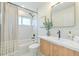 Well-lit bathroom featuring a shower-tub combo, and a single sink vanity with wood accents at 110 8Th St, Belleair Beach, FL 33786