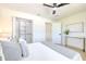 A calming bedroom featuring a ceiling fan, an organized closet, and light walls complemented by a console table at 110 8Th St, Belleair Beach, FL 33786