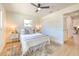 Bright bedroom featuring a ceiling fan, white walls, light-colored flooring, and a comfortable bed with stylish linens at 110 8Th St, Belleair Beach, FL 33786
