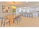 Elegant dining area adjacent to a modern kitchen, featuring a unique light fixture and contemporary design at 110 8Th St, Belleair Beach, FL 33786
