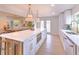 Bright kitchen with white cabinets, quartz countertops, stainless steel appliances, and an island with bar seating at 110 8Th St, Belleair Beach, FL 33786