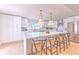 Modern kitchen with white cabinets, stainless steel appliances, a spacious island with seating, and stylish pendant lighting at 110 8Th St, Belleair Beach, FL 33786