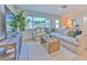 Cozy living room bathed in natural light with a plush sofa, stylish rug, and scenic outdoor views at 110 8Th St, Belleair Beach, FL 33786