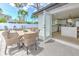 Inviting patio with a dining table and chairs, seamlessly connecting the indoor kitchen with outdoor entertainment at 110 8Th St, Belleair Beach, FL 33786