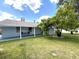 A large backyard with mature landscaping, and a covered patio at 11303 Hollyglen Dr, Tampa, FL 33624