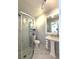Modern bathroom featuring a glass-enclosed shower, pedestal sink, and marble tile at 11303 Hollyglen Dr, Tampa, FL 33624