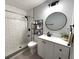 Bathroom featuring a walk-in shower and updated vanity with a round mirror at 11303 Hollyglen Dr, Tampa, FL 33624