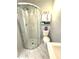 Bright bathroom featuring a glass-enclosed shower, white tiling, and pedestal sink at 11303 Hollyglen Dr, Tampa, FL 33624