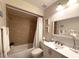 Cozy bathroom with a shower-tub combination, white vanity, and neutral tile at 11303 Hollyglen Dr, Tampa, FL 33624