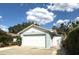 Exterior featuring an attached garage, well-maintained landscaping, and a brick facade at 11303 Hollyglen Dr, Tampa, FL 33624