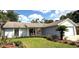 Well-manicured front lawn and mature landscaping enhance this one-story home's curb appeal at 11303 Hollyglen Dr, Tampa, FL 33624