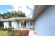 Inviting covered front porch perfect for relaxing, featuring elegant brickwork and lush landscaping at 11303 Hollyglen Dr, Tampa, FL 33624