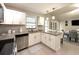 Modern kitchen featuring white cabinets, granite countertops, and stainless steel appliances, with dining area views at 11303 Hollyglen Dr, Tampa, FL 33624
