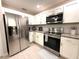 Well-lit kitchen featuring stainless steel appliances, white cabinetry, and granite countertops at 11303 Hollyglen Dr, Tampa, FL 33624