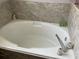 White soaking tub features tiled accents at 11727 Spanish Lake Dr, Tampa, FL 33635