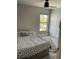 Neutral bedroom featuring a ceiling fan, a window with outside view, and a double-door closet at 11727 Spanish Lake Dr, Tampa, FL 33635