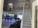 Open-concept living space with high ceilings, tile floors, a modern kitchen, and stairs to the second floor at 11727 Spanish Lake Dr, Tampa, FL 33635