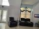 Living room featuring two plush recliners, high ceilings and large windows with decorative curtains at 11727 Spanish Lake Dr, Tampa, FL 33635