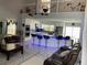 Bright, open-concept living space with tile floors, modern furniture, a kitchen island, and high ceilings at 11727 Spanish Lake Dr, Tampa, FL 33635
