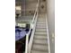 Staircase with white railings leading to the upper level, overlooking an open-concept kitchen and living area at 11727 Spanish Lake Dr, Tampa, FL 33635