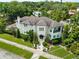 Expansive home with lush landscaping, a tile roof, manicured lawn, and mature trees at 124 Estado Ne Way, St Petersburg, FL 33704