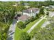 A grand home with a detached garage, brick driveway, lush foliage, and manicured lawns at 124 Estado Ne Way, St Petersburg, FL 33704