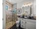 Bathroom with glass shower, dark tile floors, and granite countertops at 124 Estado Ne Way, St Petersburg, FL 33704