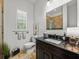 Well-lit bathroom features a dark vanity, decorative mirror, and a window with bright natural light at 124 Estado Ne Way, St Petersburg, FL 33704